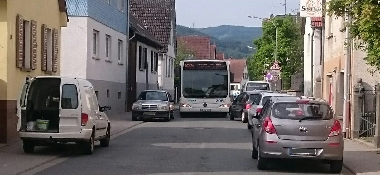 parkende PKWs behindern einen Linienbus